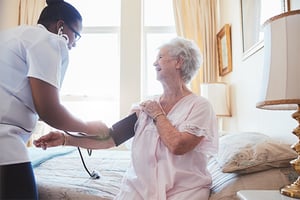 nurse-visiting-senior-female-patient-taking-blood-pressure